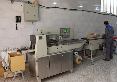 دستگاه بسته‌بندی در کارخانهٔ مبتکران